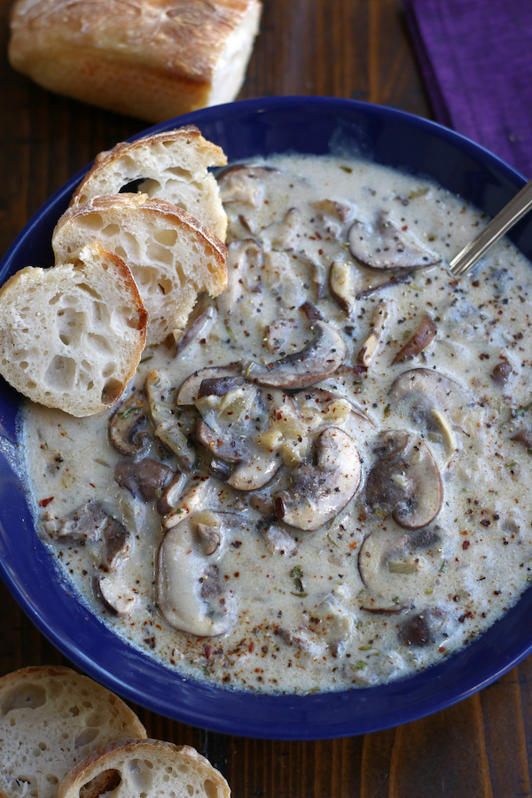 Mushroom Soup Served into a blur bowl and garnished with red chili pepper flakes.