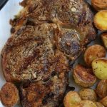 Air Fryer Ribeye on a white plate with crispy potatoes.