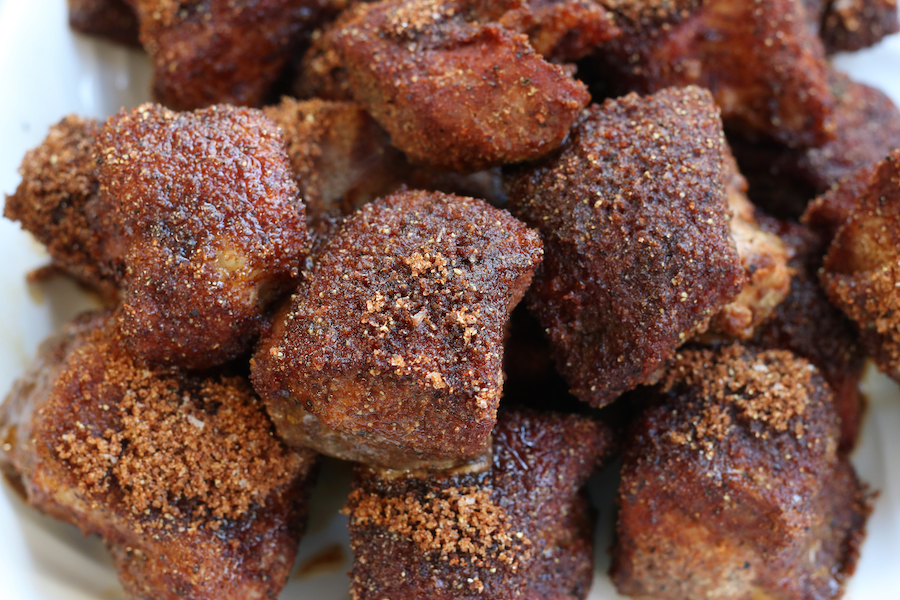 Up close photo of Country Style Pork Ribs with dry rub on a white platter.