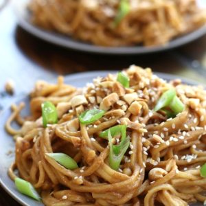 Two plates of Easy Peanut Noodles garnished with green onions.