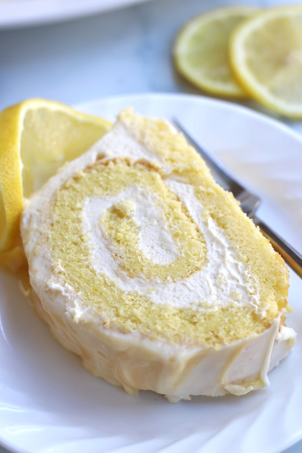 A slice Lemon Cake Roll with lemon slices.