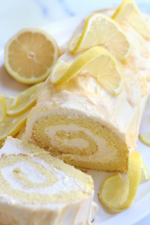 Lemon Roll cake sliced on a white platter.