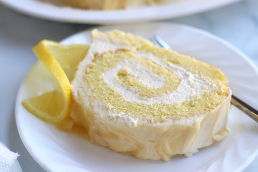 A slice of Lemon Roulade served on a white plate.