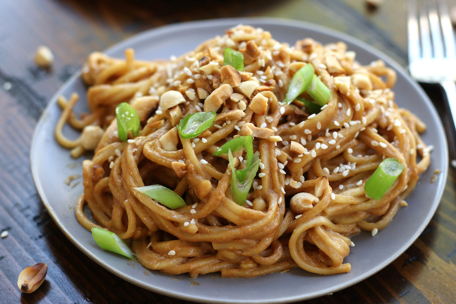 Peanut Butter Noodles garnished with green onions, sesame seeds and peanuts.