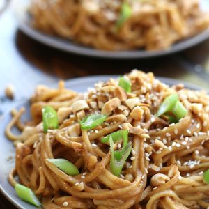 Peanut Noodles served on a plate that is sitting on a table.