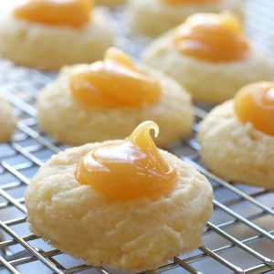 Whipped Lemon Shortbread Cookies with lemon curd lined up on a cooling wrack.