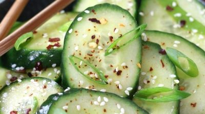 Asian Cucumber Salad served a grey bowl with wooden chopsticks.