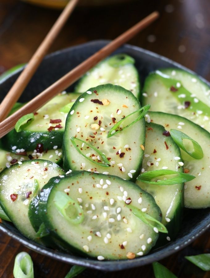 Asian Cucumber Salad served a grey bowl with wooden chopsticks.