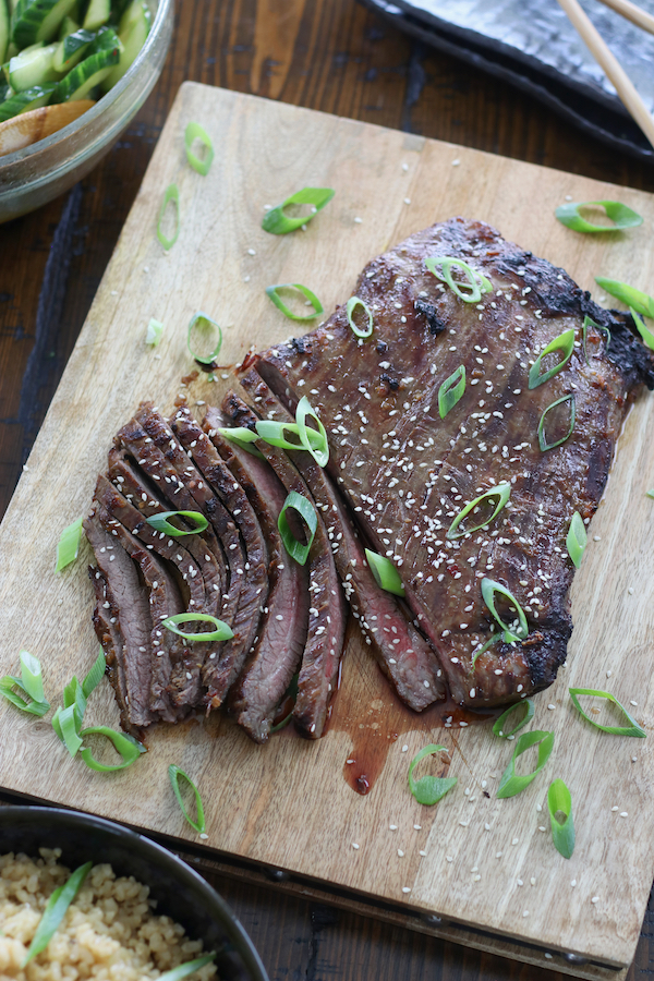 Prepared dinner on wooden table with the star being flank steak marinated with Simple Asian Style Steak Marinade and then grilled in an Air Fryer.
