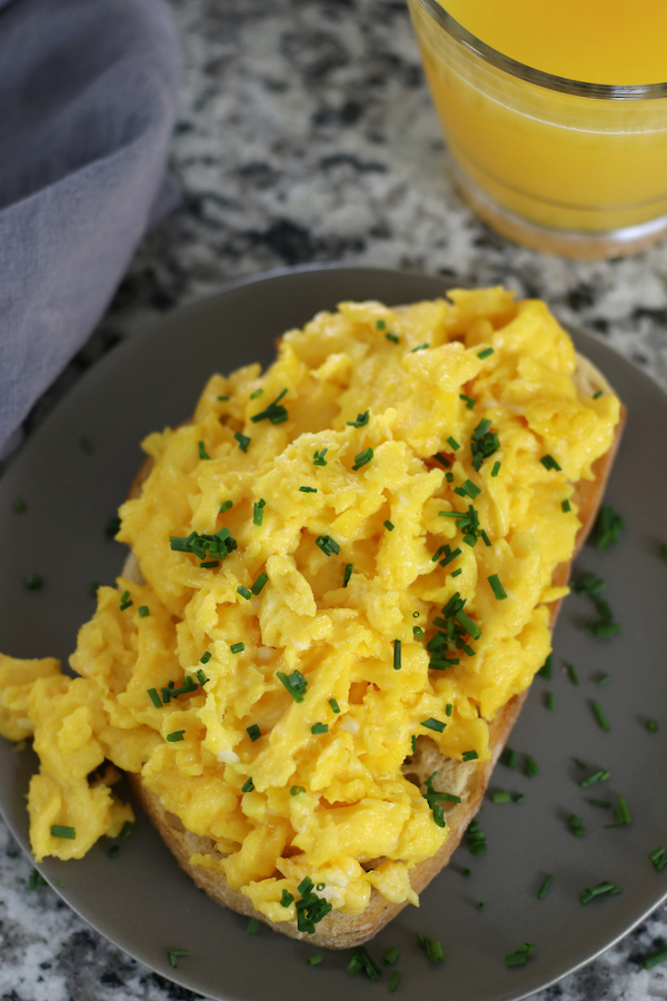Fluffy Scrambled Eggs on toast garnished with chives.