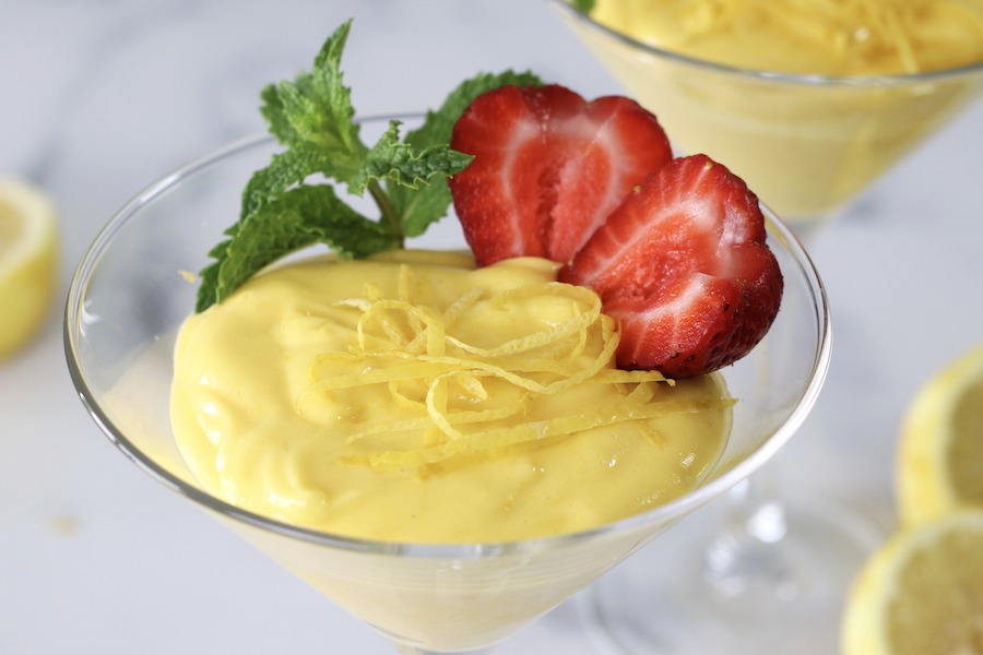 Italian custard served in a martini glass and garnished with lemon zest, fresh mint and strawberries.