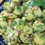 No-mayo Potato Salad in a blue bowl sitting on a wooden table.