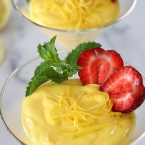 Zabaglione recipe made with limoncello and garnished with fresh mint and a cut strawberry.