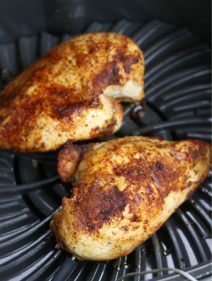 Two all purpose Air Fryer Boneless Chicken Breasts side by side in air fryer.