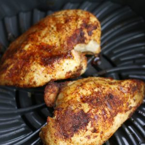 Cooked Chicken Breasts in Air Fryer sitting on the grill grate.