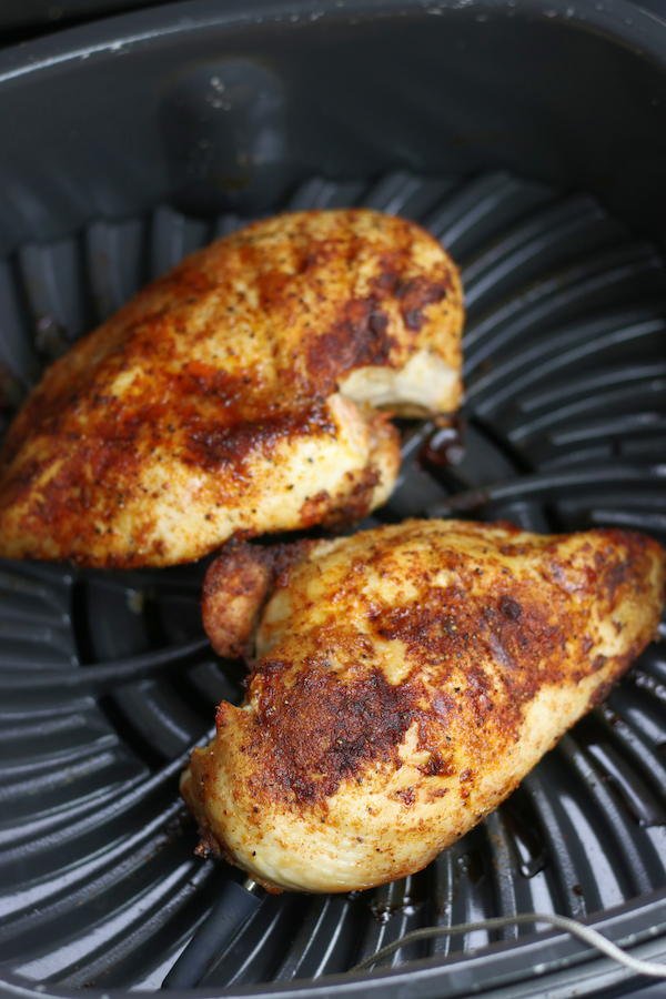 Cooked Chicken Breasts in Air Fryer sitting on the grill grate.