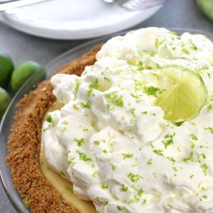 Homemade Key Lime Pie with fluffy lime whipped cream and a graham cracker and coconut crust.