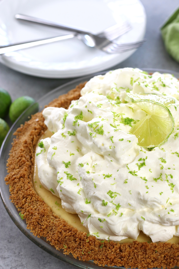 Homemade Key Lime Pie with fluffy lime whipped cream and a graham cracker and coconut crust.