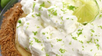 Up close photo of Key Lime Pie with fluffy lime whipped cream.
