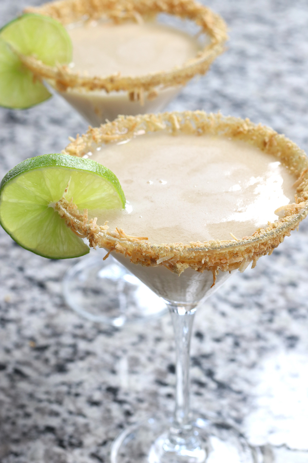Up close photo of two Key Lime Martinis garnished with toasted coconut and graham cracker crumbs.