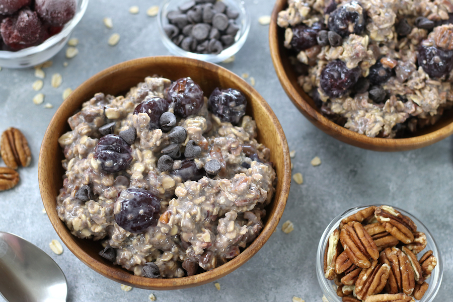 Cherry Oats for Breakfast on a countertop surrounded by pecans and chocolate chips.