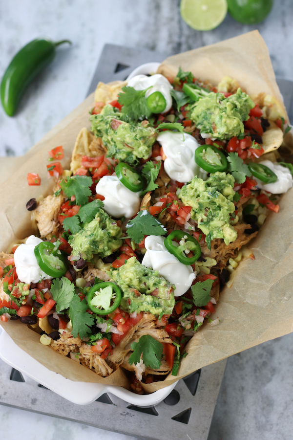 A pan of Pulled Chicken Nachos sitting on a metal trivet.