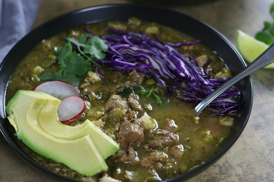 Green Pork Pozole served in a black bowl.