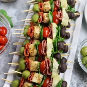 Antipasta Skewers with artichoke hearts on a white platter.