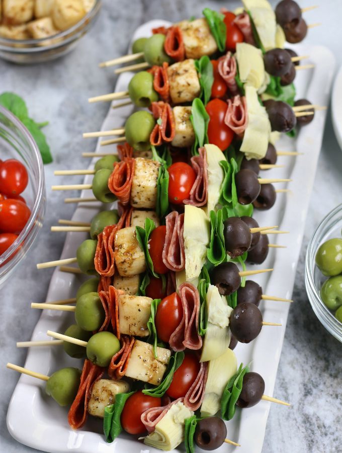 Antipasta Skewers with artichoke hearts on a white platter.