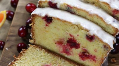 Overhead photo of a sliced Orange Cranberry Bread with an orange glaze.