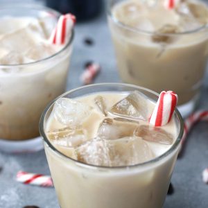 Peppermint White Russian Recipe served in short glasses and garnished with peppermint sticks.