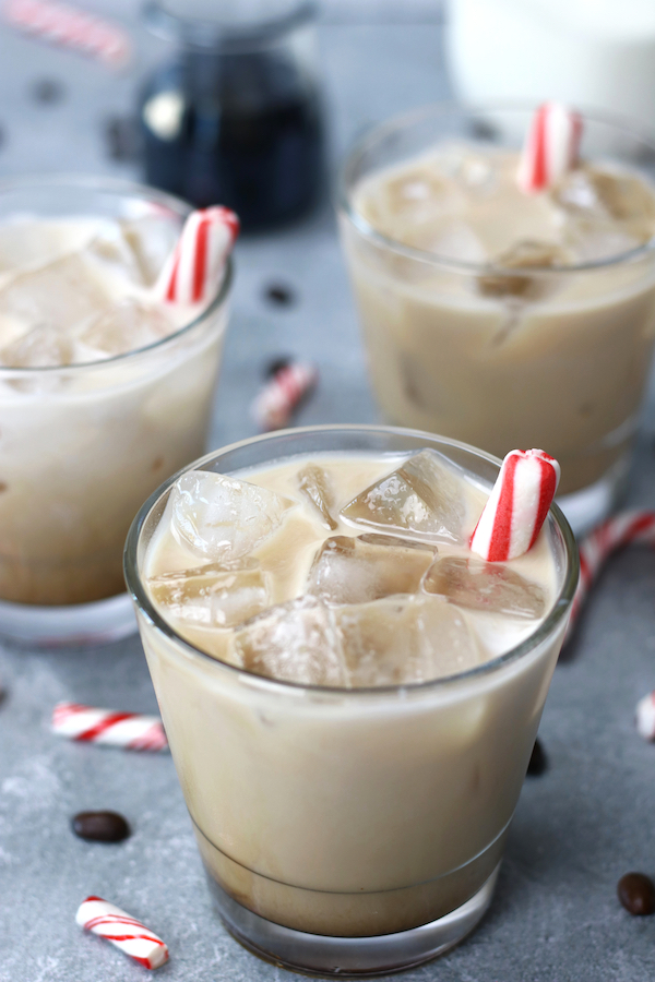 Peppermint White Russian Recipe served in short glasses and garnished with peppermint sticks.