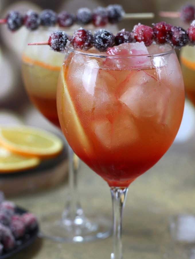 Up close photo of a Winter Spritz garnish with sugared cranberries.