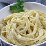 A big bowl of Alfredo sauce served on bucatini pasta.