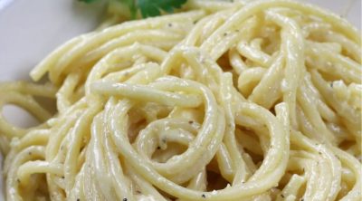 A big bowl of Alfredo sauce served on bucatini pasta.