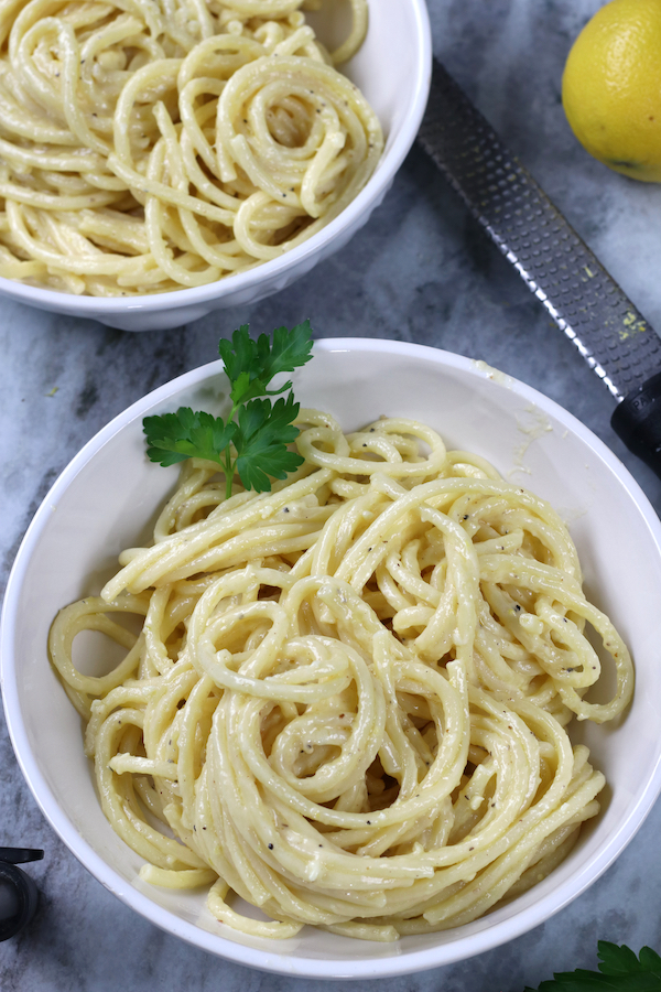 Overhead photo of Garlic Alfredo Sauce covering pasta and garnished with Italian parsley.