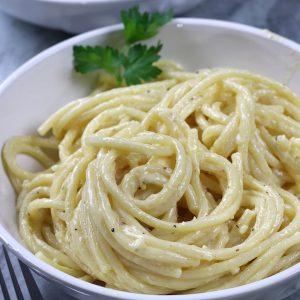 Homemade Alfredo Sauce served on pasta in a white pasta bowl.