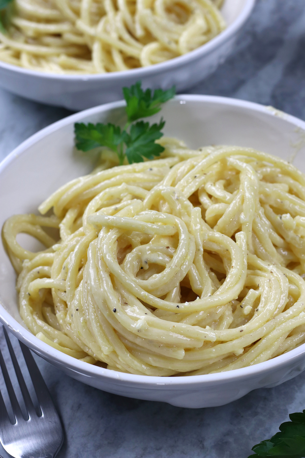 Homemade Alfredo Sauce served on pasta in a white pasta bowl.