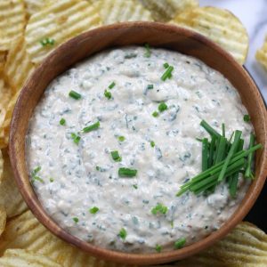 Roasted Garlic Dip served in a brown bowl and garnished with fresh chives.