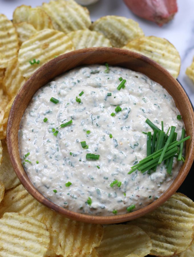 Roasted Garlic Dip served in a brown bowl and garnished with fresh chives.