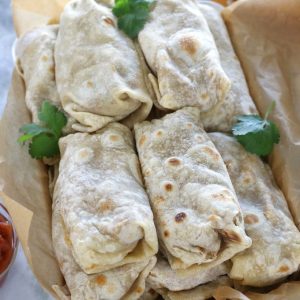 Overhead photos of Frozen Bean and Cheese Burritos piled in a roasting pan before freezing.