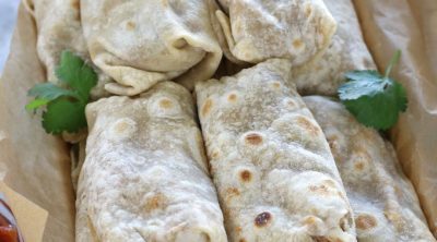 Overhead photos of Frozen Bean and Cheese Burritos piled in a roasting pan before freezing.