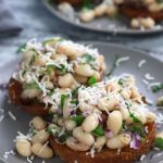 Marinated White Beans on olive oil toast and garnished with freshly grated parmesan.