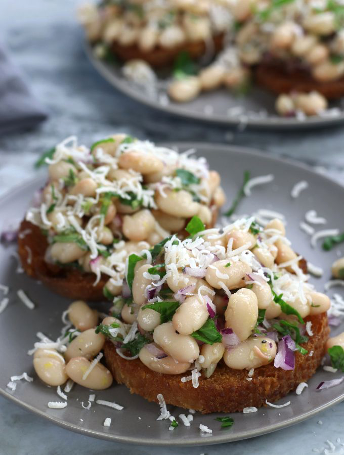Marinated White Beans on olive oil toast and garnished with freshly grated parmesan.