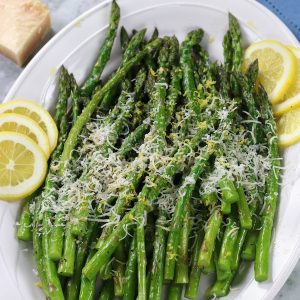 An overhead photo of roasted Parmesan Asparagus on a white platter.