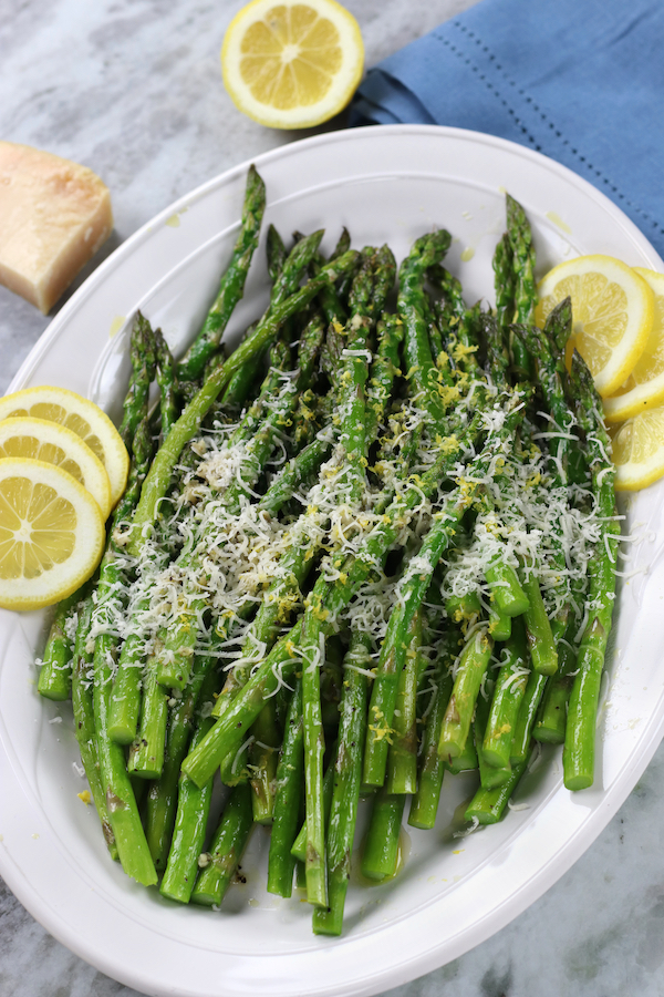 An overhead photo of roasted Parmesan Asparagus on a white platter.