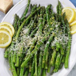 A platter of Roasted Asparagus with lemon slices.