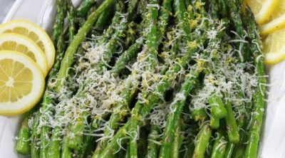 A platter of Roasted Asparagus with lemon slices.