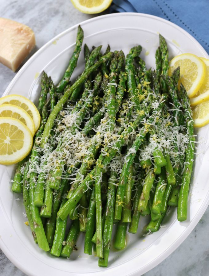 A platter of Roasted Asparagus with lemon slices.