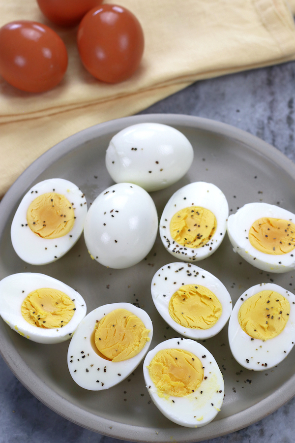 Overhead photo of Perfect Hard Boiled Eggs cut in half and sprinkled with black pepper.